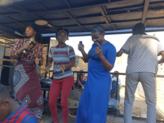 Ruth Lupanga (far left), civic education officer at the Office of the Ombudsman, dances with patrons at a public rally