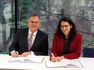 IOI Secretary General Günther Kräuter and APT Chief of Operations Barbara Bernath signing the MoU