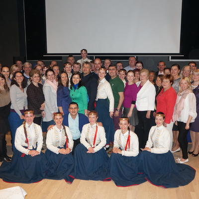 Latvian Ombudsman Juris Jansons surrounded by participants and folk dancers